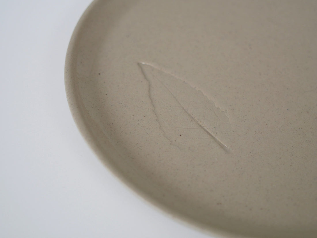 Ceramic plate carrying the imprint of a crop from Nieuw Zwanenburg