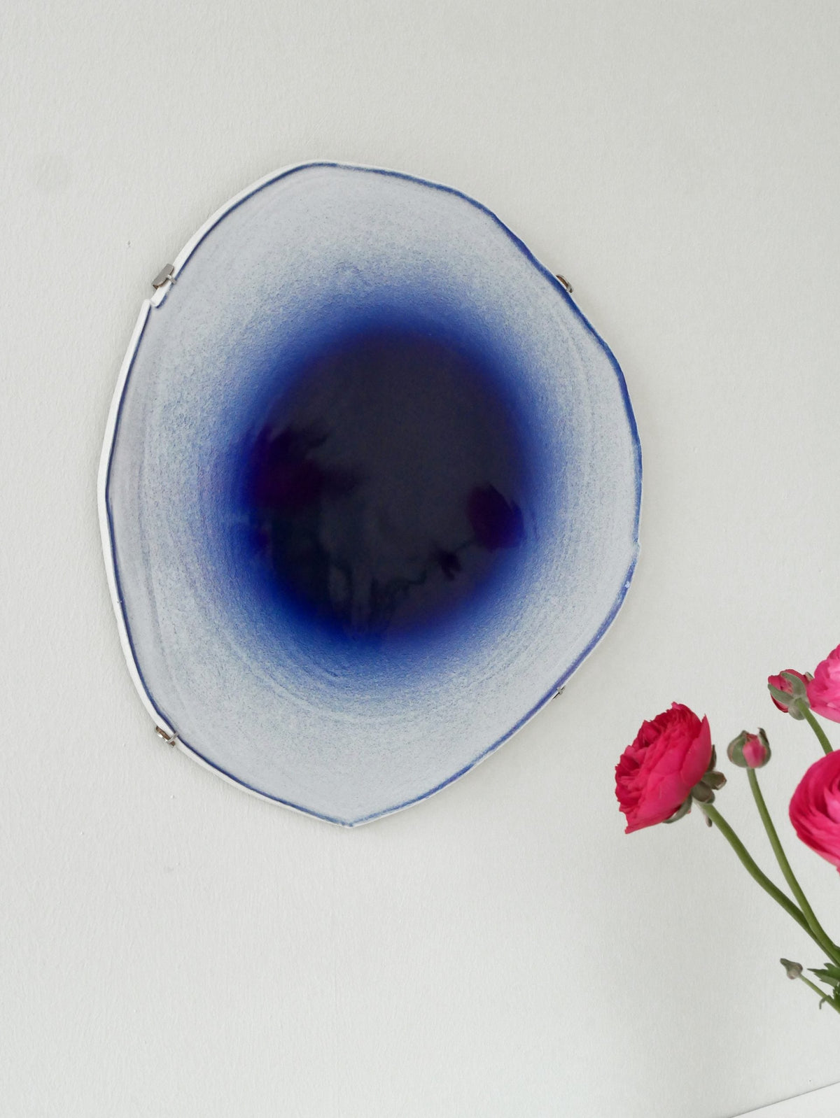 Large blue Fragments of Wonder mirror surrounded by flowers